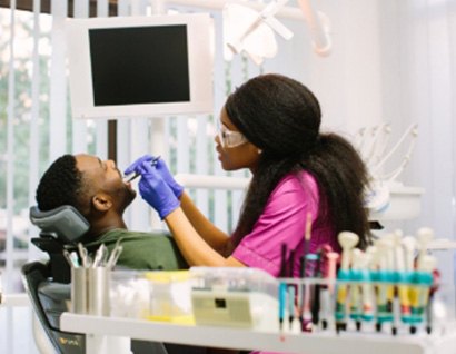 man with dental assistant looking at smile